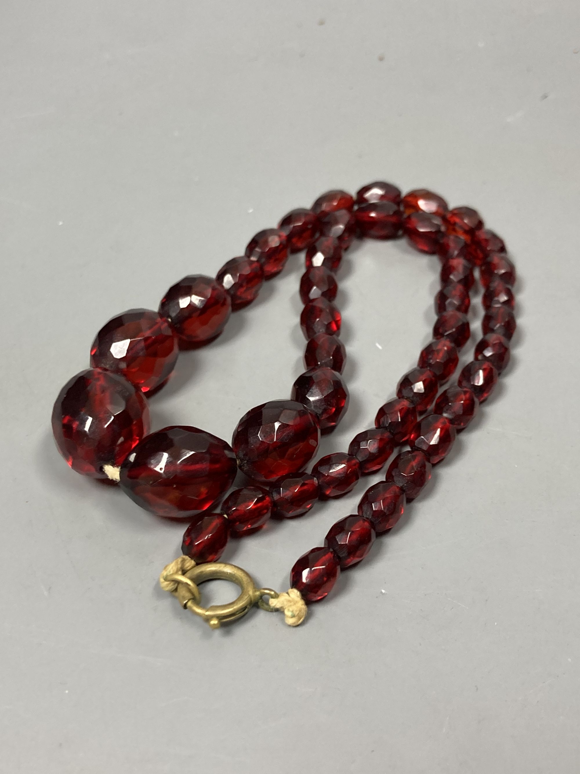 Two transluscent single strand simulated cherry amber bead necklaces, longest 82cm, gross weight 120 grams.